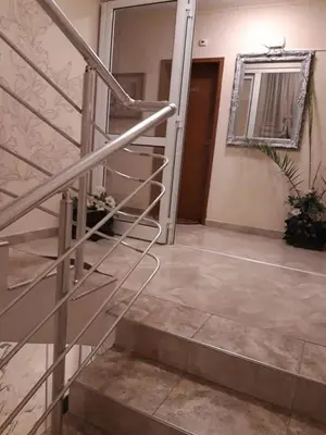 a staircase in a house with a mirror and a door at Семеен хотел Вермона in Primorsko