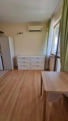 an empty living room with a table and a refrigerator at Studio in Relax Complex, Sveti Vlas in Sunny Beach