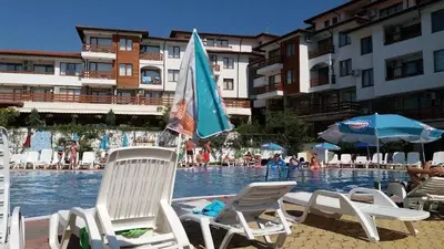 a group of chairs and umbrellas in a swimming pool at Gardenia Hills Studio in Sunny Beach
