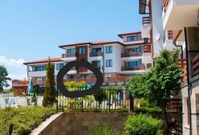 a sign on a fence in front of buildings at Gardenia Hills in Sunny Beach