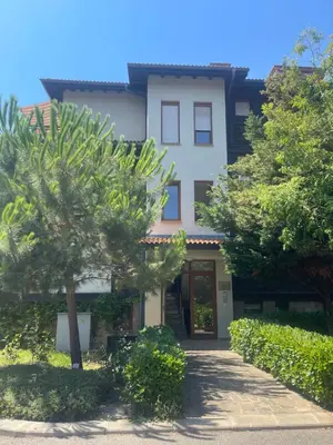 a white building with trees in front of it at Amarena Studio Santa Marina, Sozopol in Sozopol