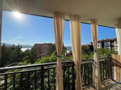 a balcony with curtains and a view of the ocean at Amarena Studio Santa Marina, Sozopol in Sozopol