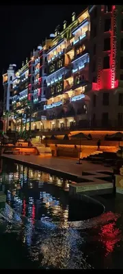 a large building at night with a body of water at Apartment 300m from private beach VILA ROMANA Royal Castle in Sveti Vlas