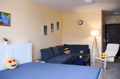 a living room with a blue couch and a bed at Sandy Dreams Cozy Studio in Pomorie