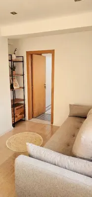 a living room with a bed and a room with a door at The Boho House with Free Parking in Nesebar