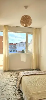 a bedroom with a bed and a large window at The Boho House with Free Parking in Nesebar