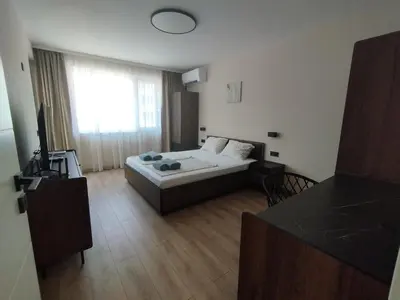 a living room with a bed and a large window at RadiSun with Free Parking space in Burgas City
