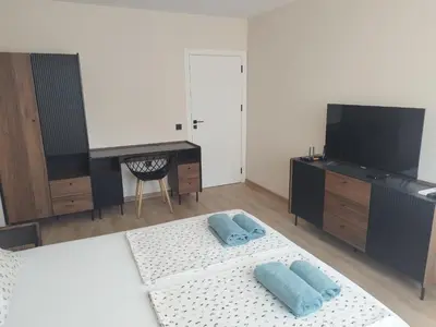 a bedroom with a desk and a bed with two blue pillows at RadiSun with Free Parking space in Burgas City