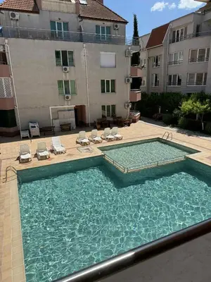 a large swimming pool with chairs and a building at Ravda14 in Ravda