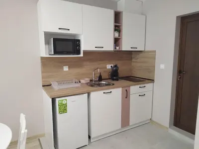 a kitchen with white cabinets and a sink and a microwave at BoriSun with Free Parking space in Burgas City