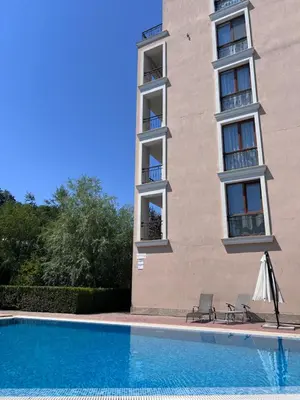a building with a swimming pool in front of a building at 2 rooms Astoria 2 Elenite in Sveti Vlas