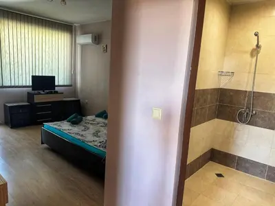 a room with a bed and a shower in a bathroom at Боровата къща in Varna City
