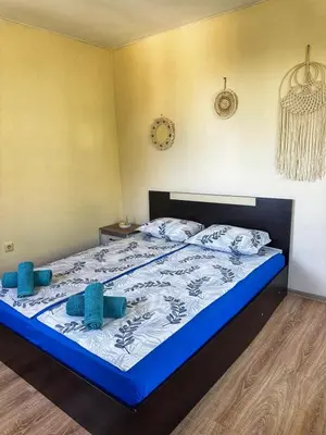a bedroom with a bed with blue pillows on it at Боровата къща in Varna City