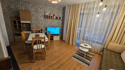a living room with a dining room table and a television at Apartment 15 Sea Grace in Sunny Beach
