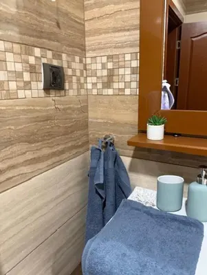a bathroom with a blue towel hanging on a wall at Апартамент Созополски Залез in Sozopol