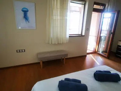 a bedroom with a bed with two blue pillows on it at Апартамент Созополски Залез in Sozopol