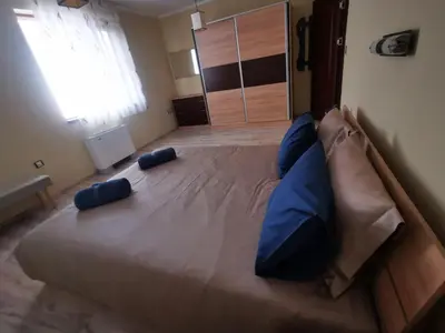 a large bed with blue pillows in a bedroom at Апартамент Созополски Залез in Sozopol