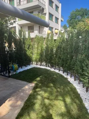 a garden with trees and grass in front of a building at Villa Maria in Sveti Vlas