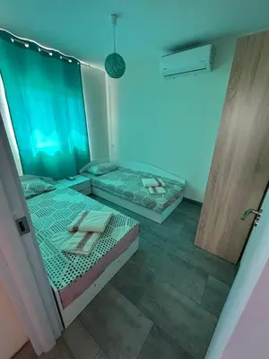 two beds in a room with blue lights at Морски Бриз in Lozenets