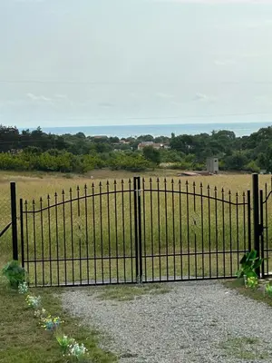 an iron gate with a view of a field at Морски Бриз in Lozenets