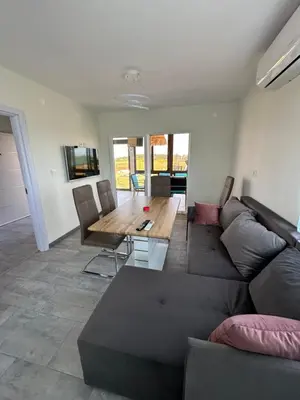 a living room with a couch and a wooden table at Морски Бриз in Lozenets