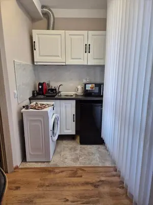 a small kitchen with white cabinets and a dishwasher at Marea Garden, Ravda - Studio with Pool by Flat Mаnager in Ravda
