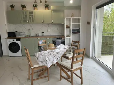 a kitchen with a table and two chairs and a kitchen with a stove at On the beach 7 in Sozopol