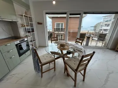 a kitchen with a table and chairs with a view of the ocean at On the beach 7 in Sozopol