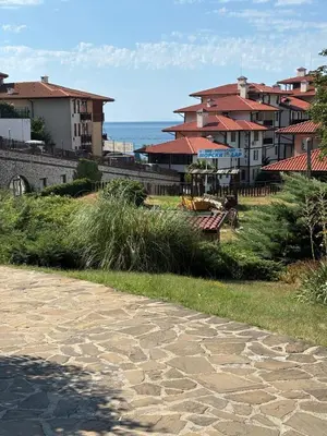 a cobblestone walkway in front of houses and the ocean at Etara 4 Sweti Wlas Apart Complex in Sveti Vlas