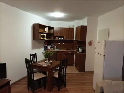 a kitchen with a table and chairs and a white refrigerator at Марина Кеѝп, Ахелой in Aheloy