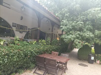 a wooden table and two chairs in a garden at Марина Кеѝп, Ахелой in Aheloy