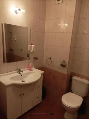 a bathroom with a sink and a toilet and a mirror at Марина Кеѝп, Ахелой in Aheloy