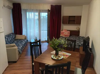 a kitchen and living room with a table and a couch at Марина Кеѝп, Ахелой in Aheloy