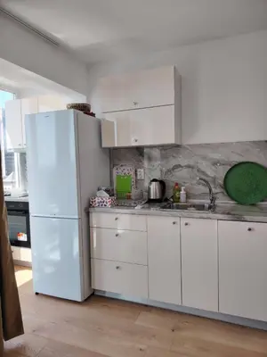 a kitchen with white cabinets and a white refrigerator at Level 5 in Burgas City