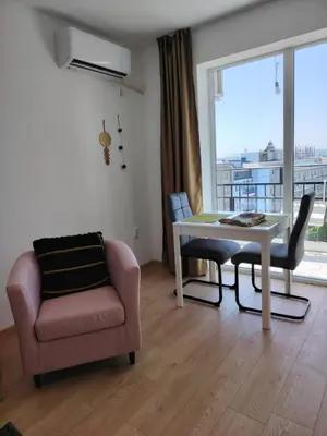 a living room with a chair and a table and a window at Level 5 in Burgas City