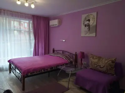 a purple bedroom with a bed and a chair at Parus 4 Studio in Pomorie