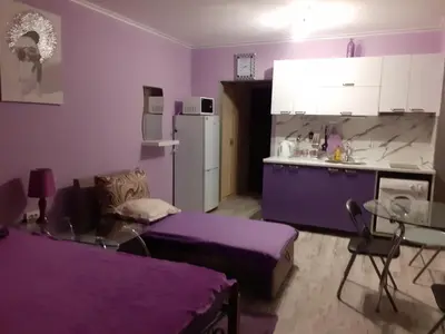 a purple kitchen with a couch and a table at Parus 4 Studio in Pomorie