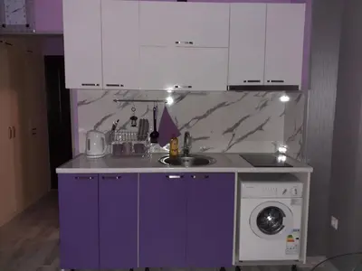 a kitchen with purple cabinets and a washing machine at Parus 4 Studio in Pomorie
