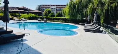 a large swimming pool with lounge chairs and umbrellas at JADORE DUNE Apartment 9 Sunny Beach in Sunny Beach