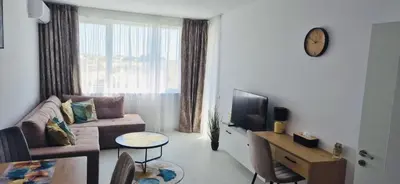 a living room with a couch and a tv and a table at JADORE DUNE Apartment 9 Sunny Beach in Sunny Beach
