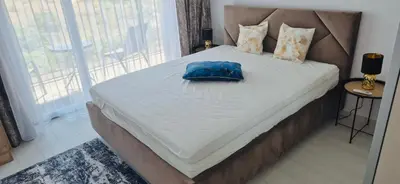 a bed with a blue pillow on top of it at JADORE DUNE Apartment 9 Sunny Beach in Sunny Beach