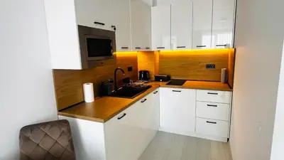 a kitchen with white cabinets and a sink and a microwave at JADORE DUNE Apartment 10 Sunny Beach in Sunny Beach