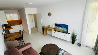 a living room with a couch and a tv on a wall at JADORE DUNE Apartment 10 Sunny Beach in Sunny Beach