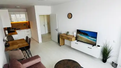 a living room with a television on a white wall at JADORE DUNE Apartment 10 Sunny Beach in Sunny Beach