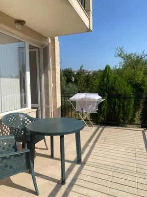 a patio with a table and a grill on a balcony at Sunny Byala in Byala
