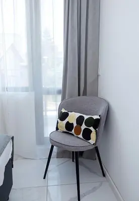 a chair with a cow pillow on it in a room at BuenaVista I Modern Comfort near Varna City Center by Flat Mаnаger in Varna City