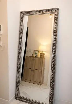 a mirror in a room with a table and a lamp at BuenaVista I Modern Comfort near Varna City Center by Flat Mаnаger in Varna City