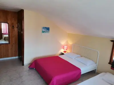 a bedroom with a large bed with a red blanket at Guest House Bа́kish Obzor in Obzor