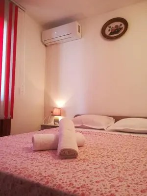 a bedroom with two beds and a towel on a bed at Guest House Bа́kish Obzor in Obzor