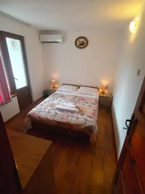 a bedroom with a bed and two lamps and a window at Guest House Bа́kish Obzor in Obzor